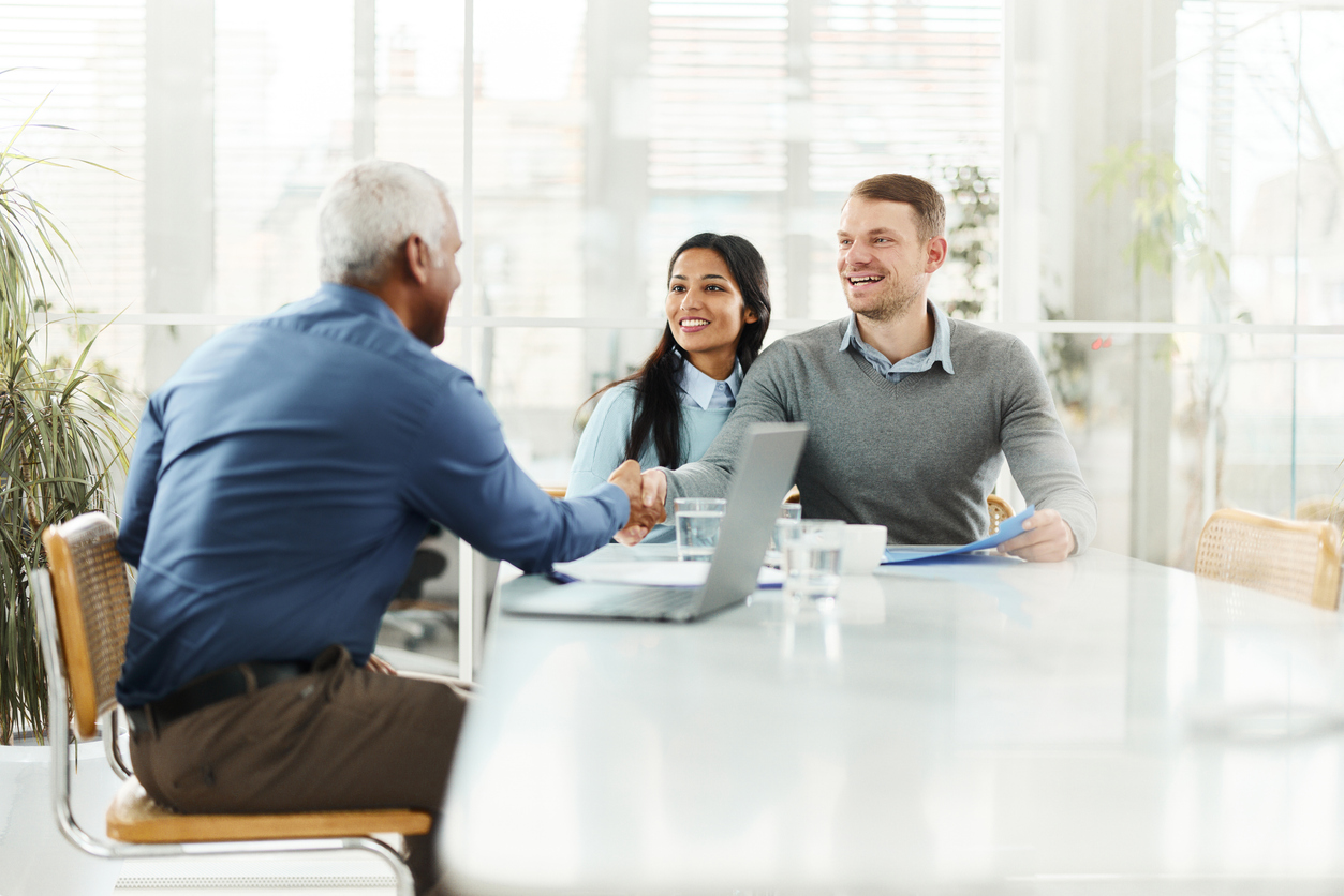 Fiduciary financial advisor talks with young couple