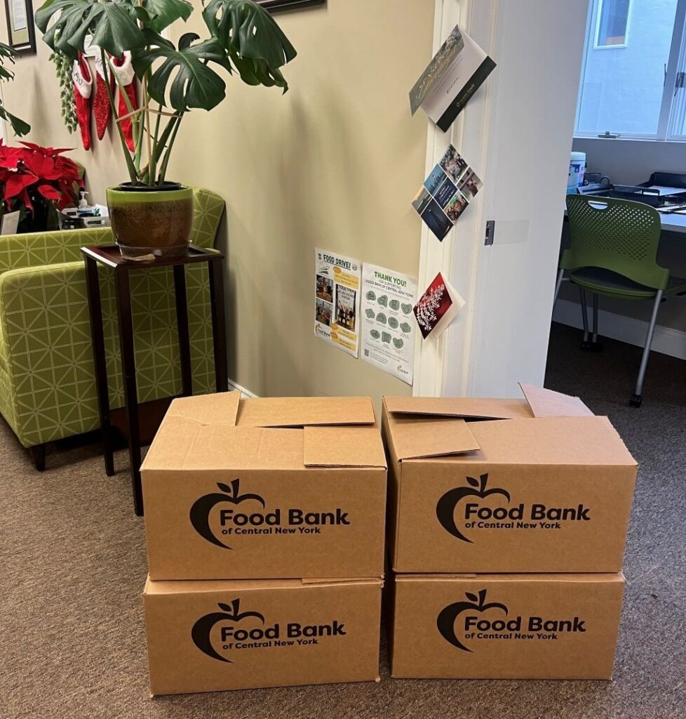 Stacked food drive boxes for the Food Bank of Central New York, prepared and ready for delivery in the HighPoint Advisors, LLC office.